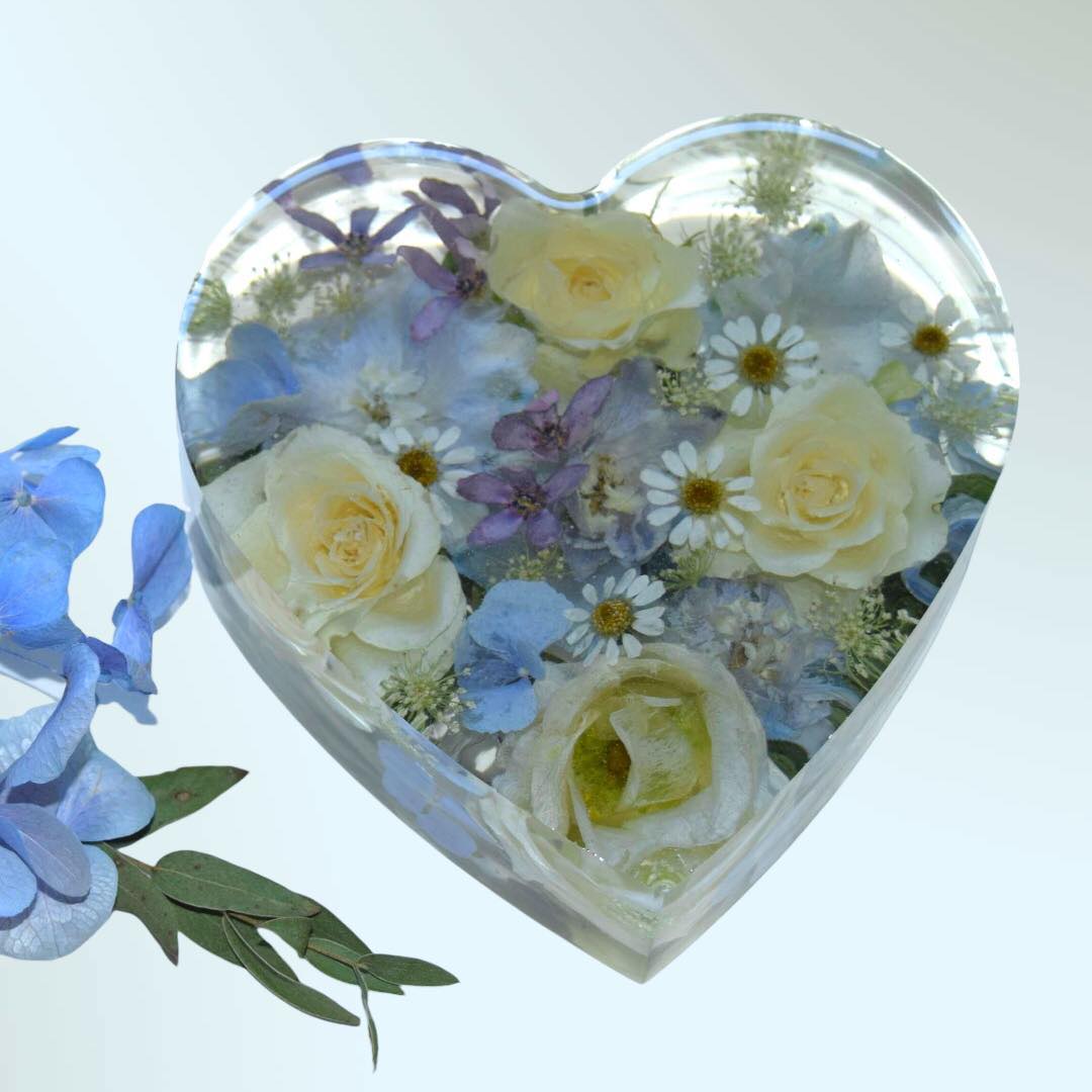 Blue and white preserved sympathy flowers embedded in a resin heart