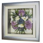 Three preserved lilac roses and eryngium in a silver effect box frame