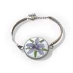 Adjustable stainless steel bracelet with pressed violet in a resin bezel
